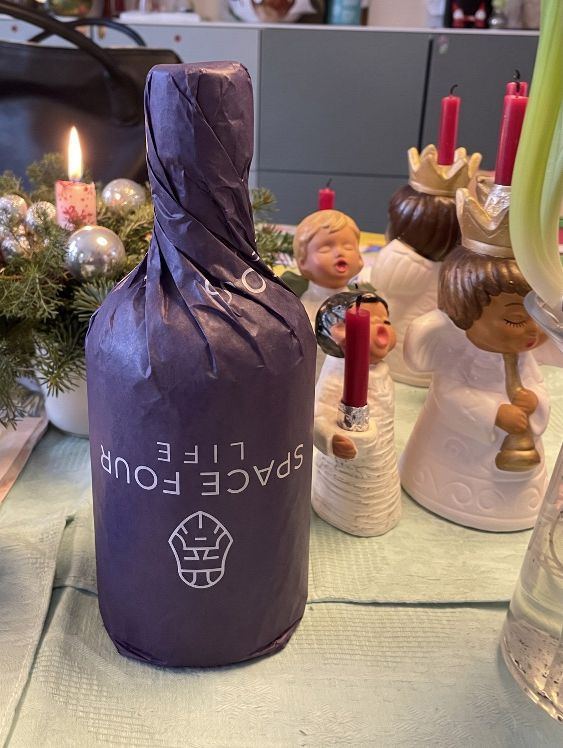 A bottle of Fenrir gin wrapped in purple tissue paper, ready to give